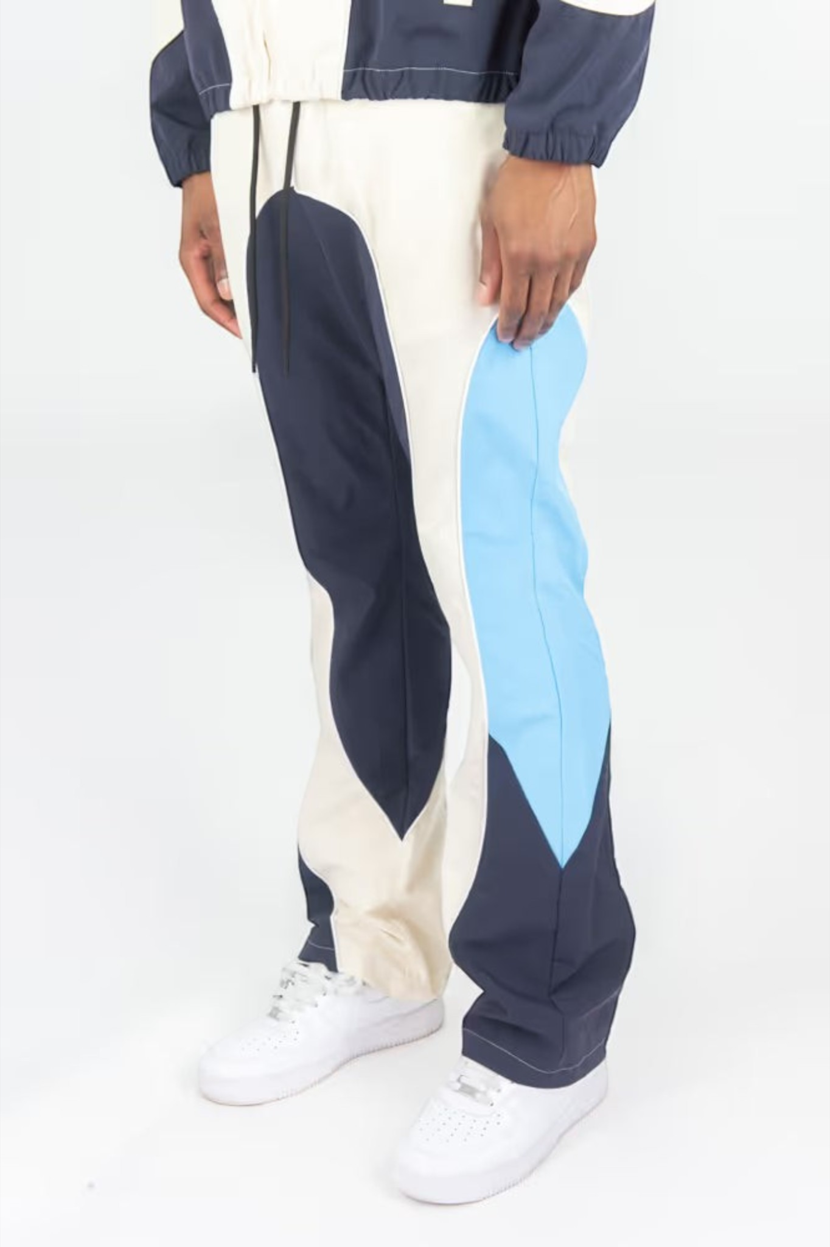 Rebel Minds cream, navy, and light blue ripstop flare-fit windbreaker pants worn with white sneakers
