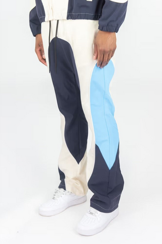 Rebel Minds cream, navy, and light blue ripstop flare-fit windbreaker pants worn with white sneakers