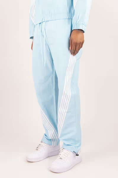 Rebel Minds light blue crinkled nylon pants featuring white contrast side stripes and an elastic drawstring waist.